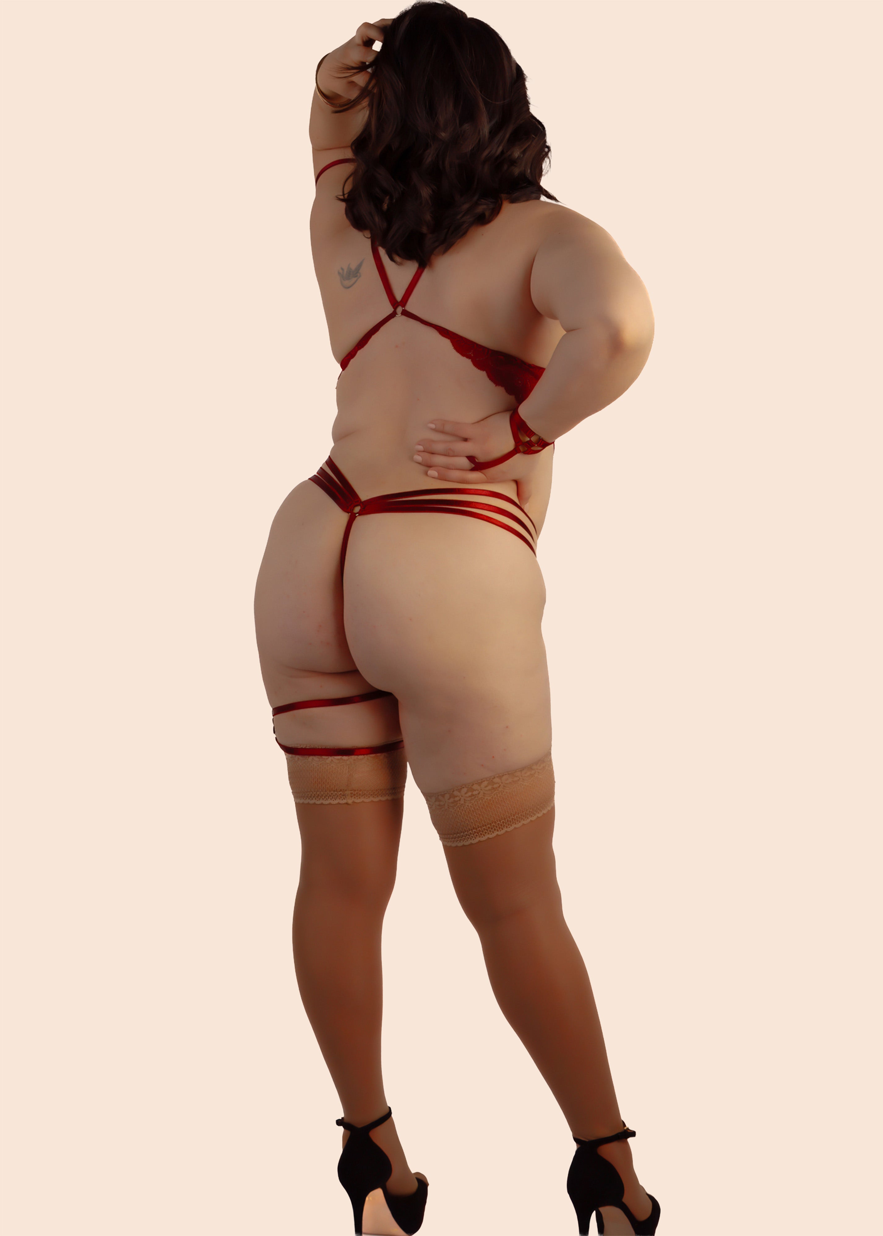 Beige bodysuit with red accents worn by a model on a beige background