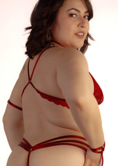 Woman wearing a red strappy top against a white background