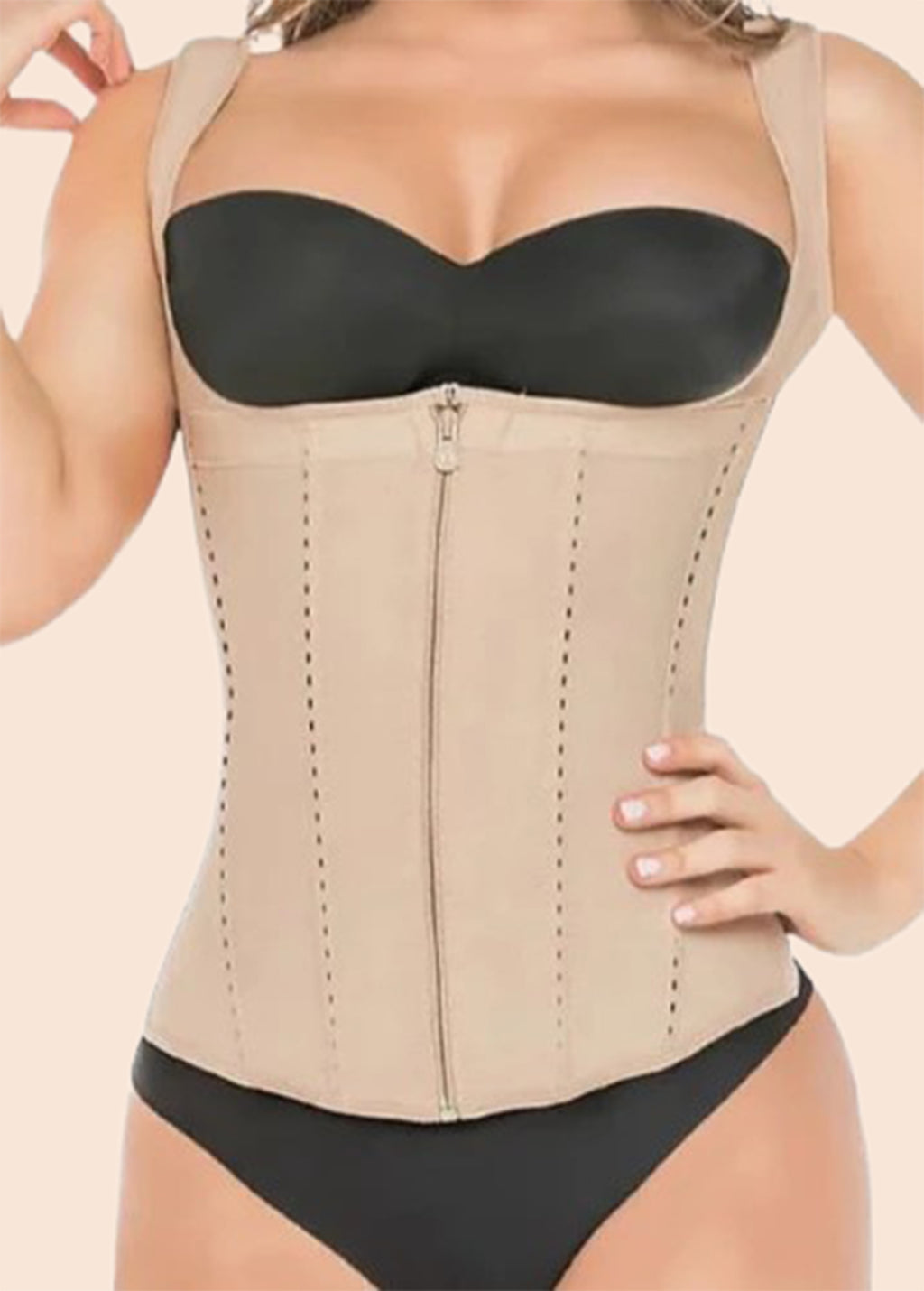 Woman wearing a beige waist trainer over a black bra and underwear set on a beige background