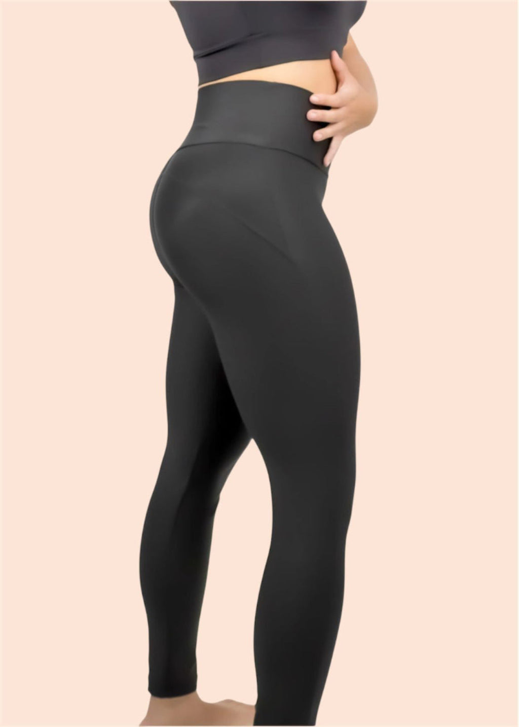Black leggings worn by a person on a beige background