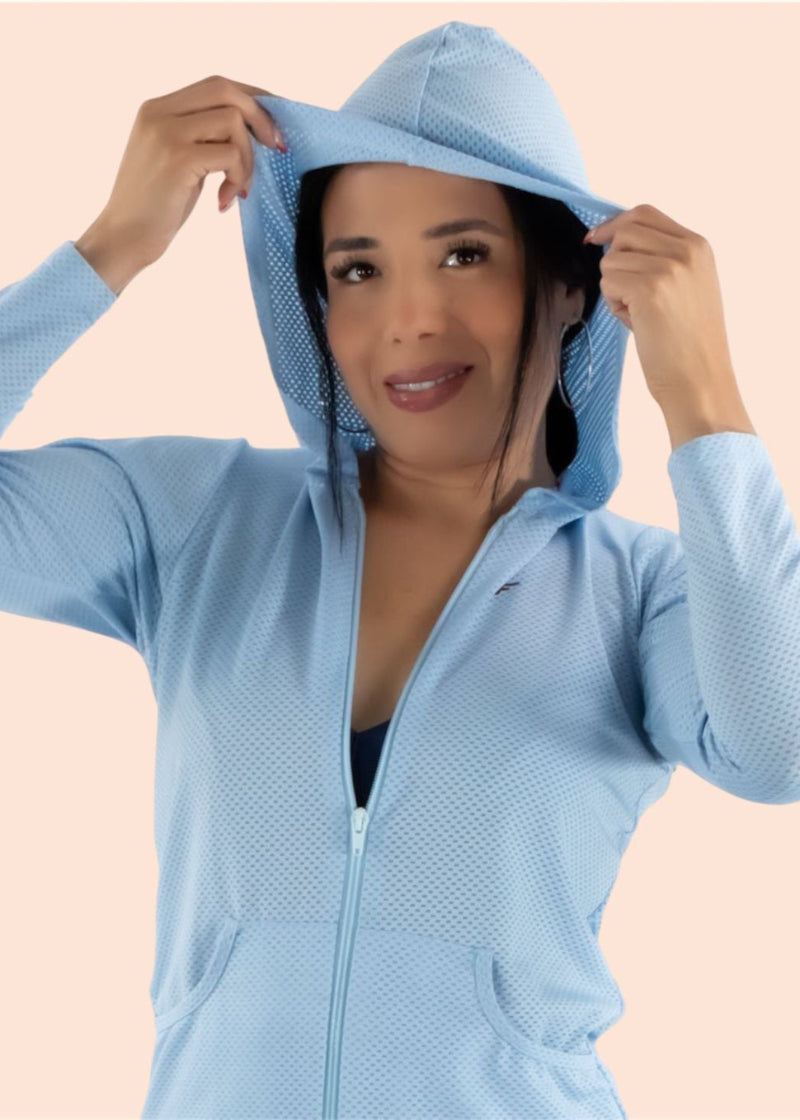 Woman wearing a light blue textured hoodie against a beige background