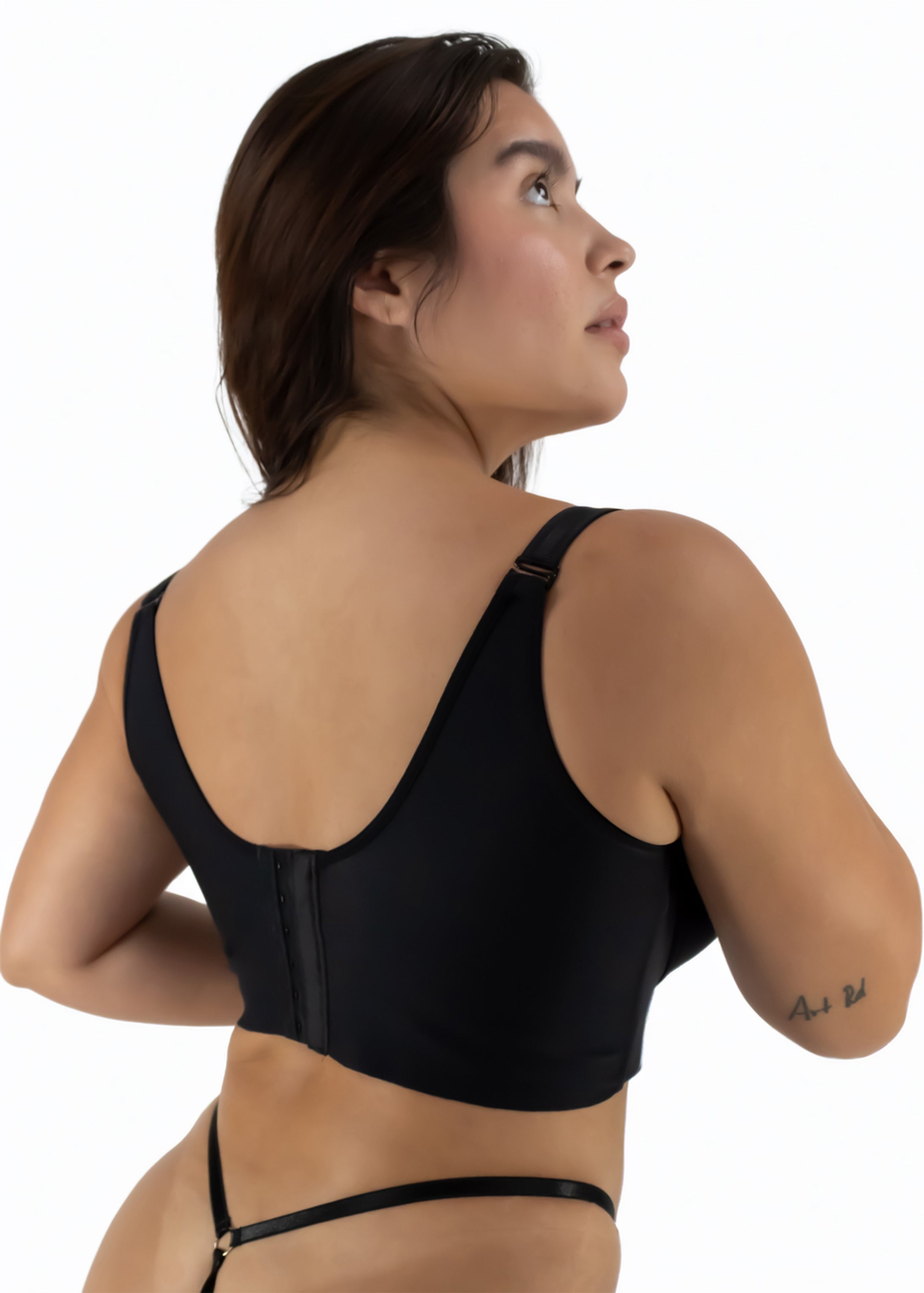 Woman wearing a black sports bra on a white background