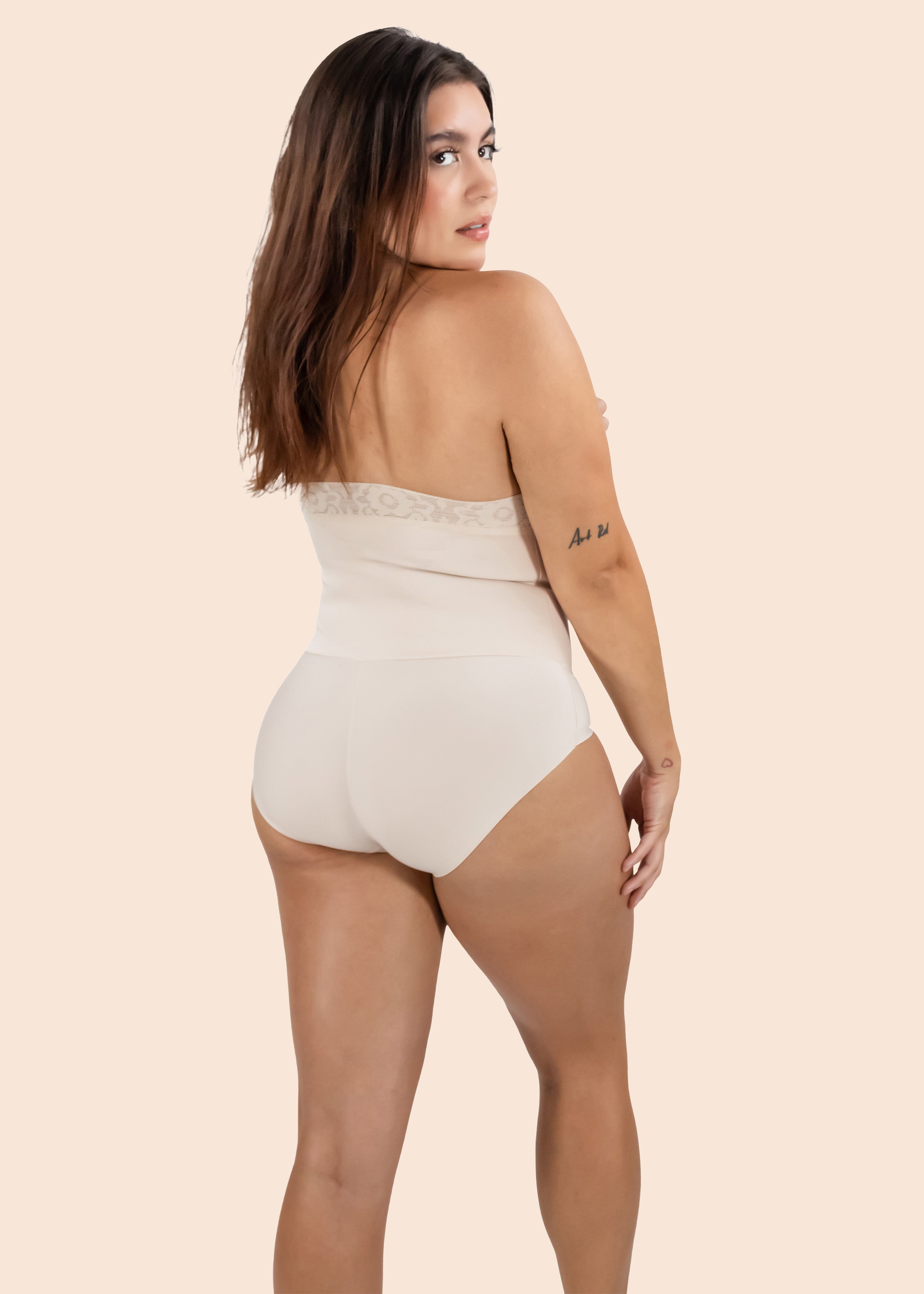Woman wearing a beige strapless bodysuit on a beige background