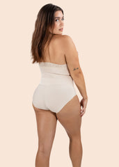 Woman wearing a beige strapless bodysuit on a beige background