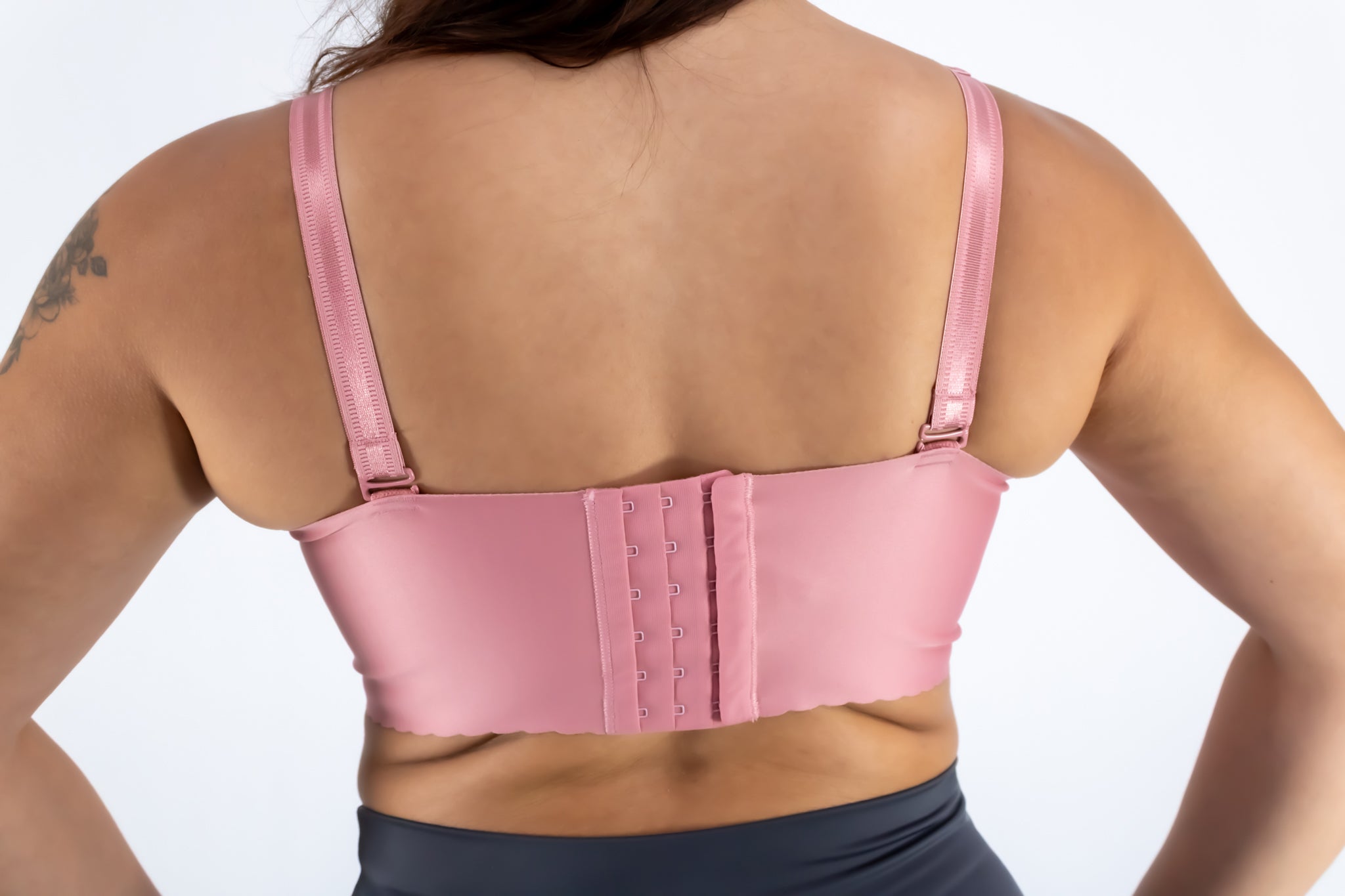 Pink sports bra worn by a person on a white background