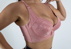 Pink lace bra on a plain background