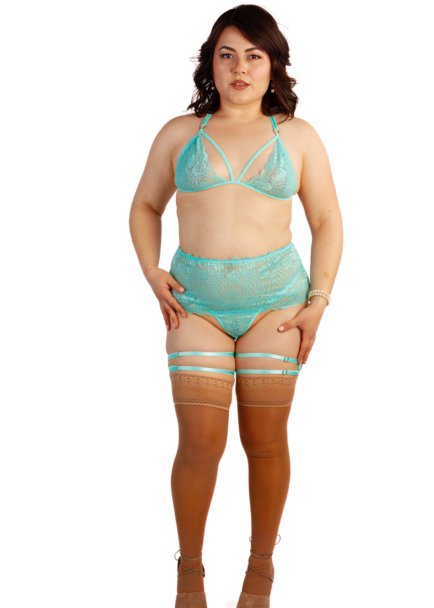 Woman wearing a turquoise lingerie set with stockings on a white background