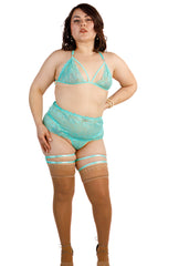 Woman wearing a teal lingerie set with stockings on a white background