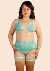 Woman wearing a turquoise lingerie set on a beige background