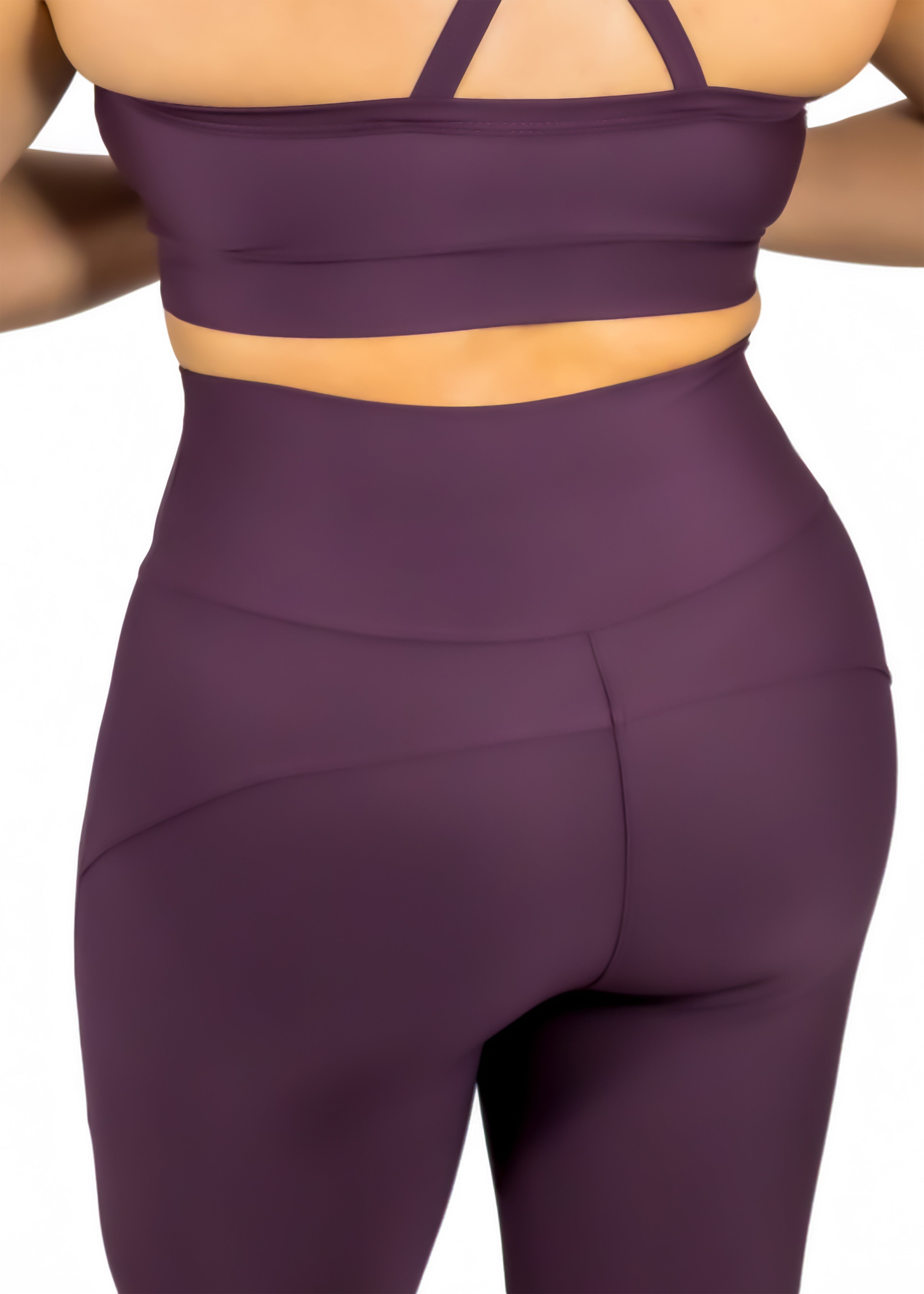 Purple athletic outfit with a sports bra and leggings on a white background